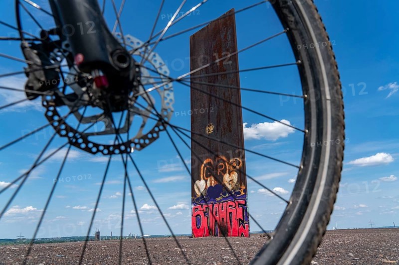 Cycling in the Ruhr area, on the Schurenbach slag heap, Bramme landmark for the Ruhr area by artist Richard Serra, Essen, North Rhine-Westphalia, Germany, Europe