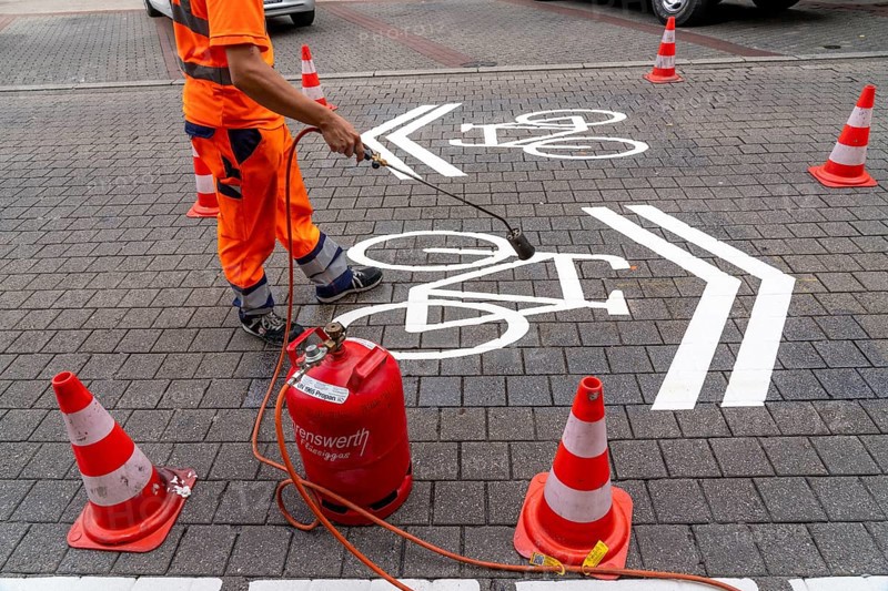Application of road markings for a cycle lane, Rüttenscheider Straße in Essen, in the shopping and gastronomy district, cyclists have right of way over motorised vehicles, part of a cycle axis through Essen's city centre
