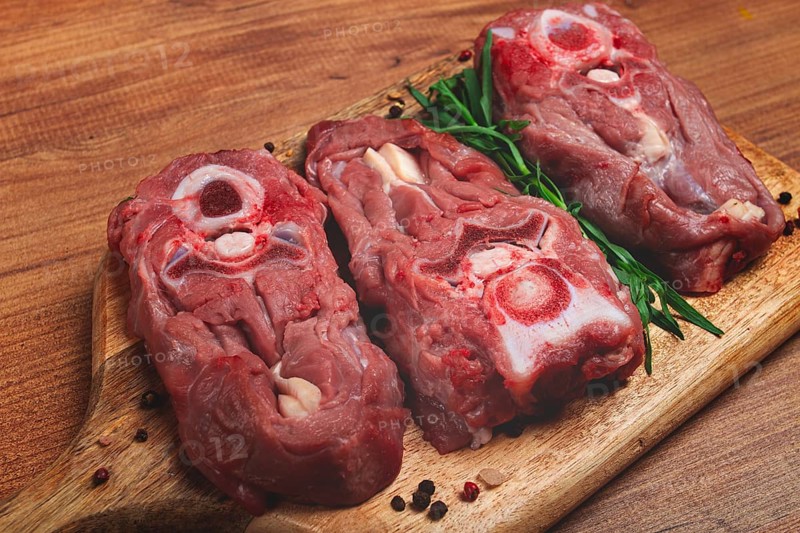 Raw steak, calf's neck on the bone, fresh meat, on the cutting board, top view, no people