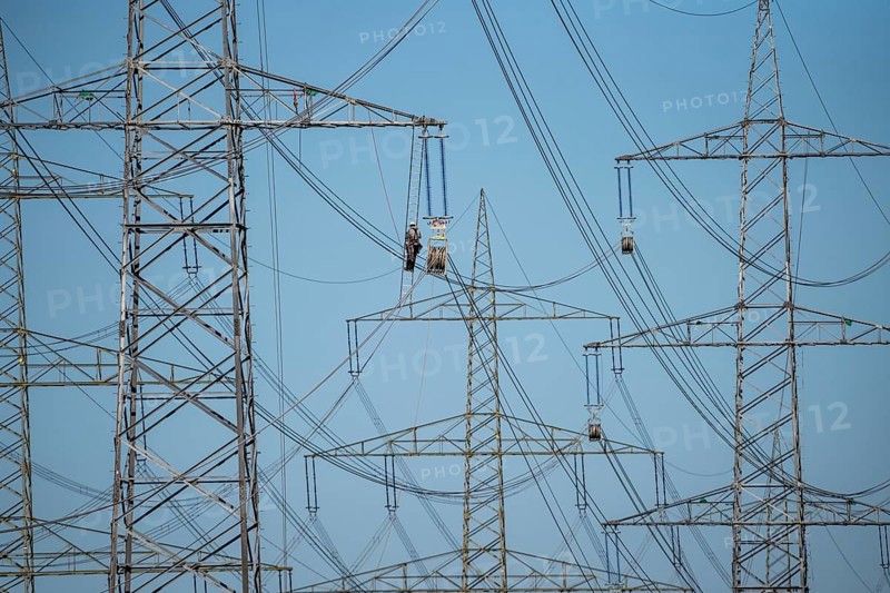 Construction of a new line route, 380 KV extra-high voltage line between Osterath and Gohr, near Neuss, fitter on ladder at great height, tensioning the lines, North Rhine-Westphalia, Germany, Europe