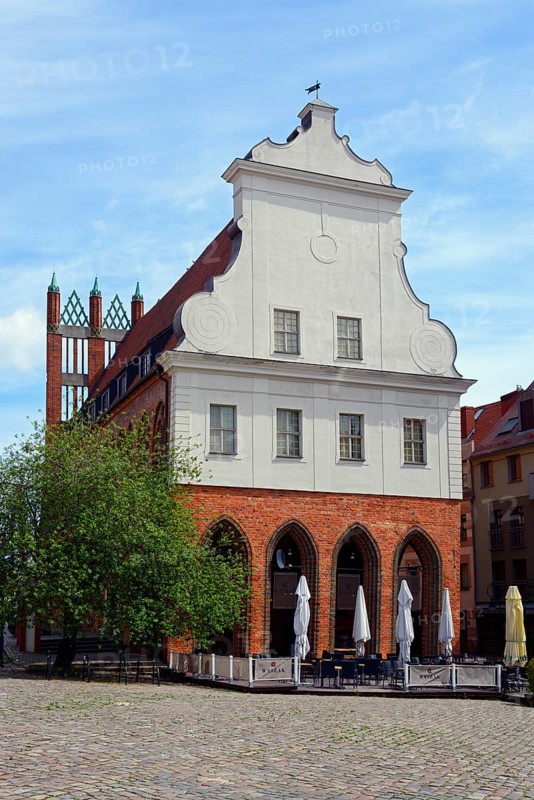 Historic gabled house on a cobbled town square with closed parasols and a tree, Old Town Hall on Haymarket, Ratusz Staromiejski, Old Town, Szczecin, Szczecin, West Pomeranian Voivodeship, Poland, EuropeHistoric gabled house on a cobbled town square with closed parasols and a tree, Europe