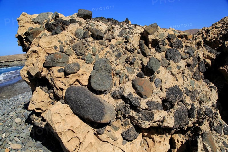 Conglomerate rock with volcanic bombs embedded in sediment, Playa de Garcey, Fuerteventura, Canary Islands, Spain, Europe