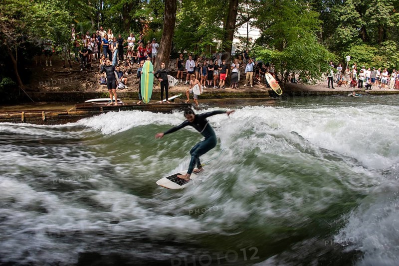 Surfers in the Eisbach, numerous onlookers on the banks, Eisbach wave in the English Garden is known worldwide, Munich, Bavaria, Germany, Europe