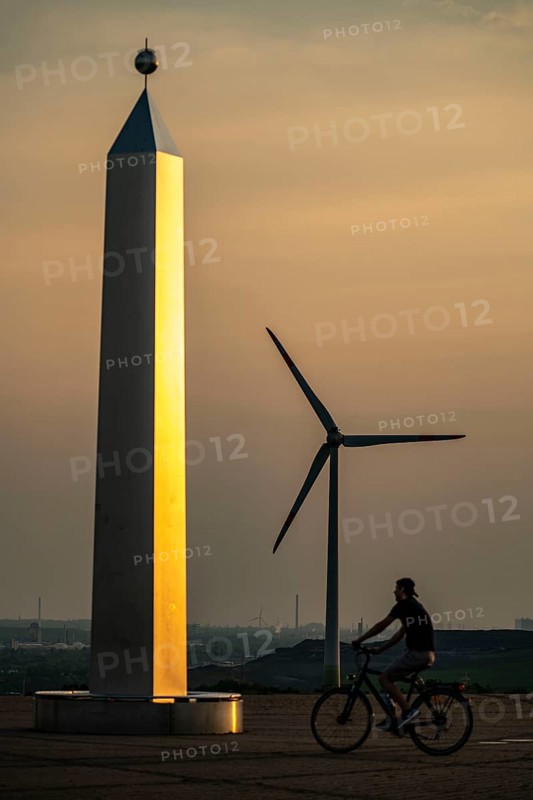 Evening atmosphere on the Hoheward spoil tip, the largest spoil tip in the Ruhr area, between Herten and Recklinghausen, sundial, obelisk of the horizontal observatory, wind power station on the Hoppenbruch spoil tip, Gelsenkirchen, North Rhine-Westphalia, Germany, Europe