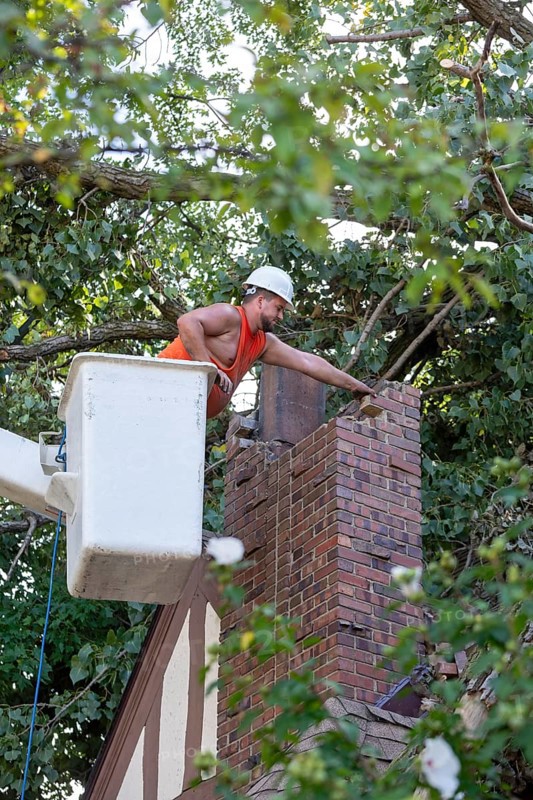 Detroit, Michigan, A worker dismantles a brick chimney after a storm with 70mph wind gusts blew down a 15-ton, 110-foot cottonwood. The tree cracked the chimney, leaving it leaning and threatening to crash through the home's roof