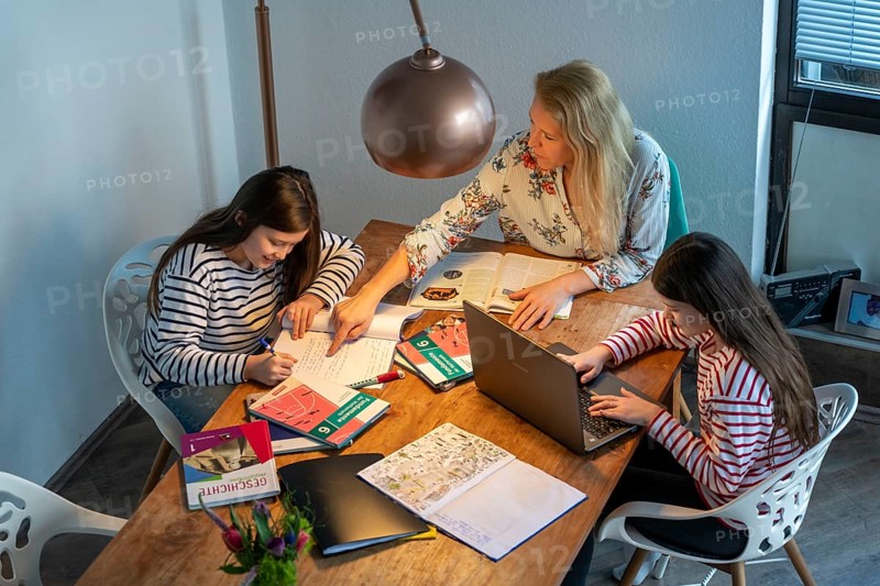 Homeschooling, during the lockdown in January 2021, mother helps her two daughters, at home, learning, with textbooks and computers, school closures, distance learning, effects of the corona crisis in Germany