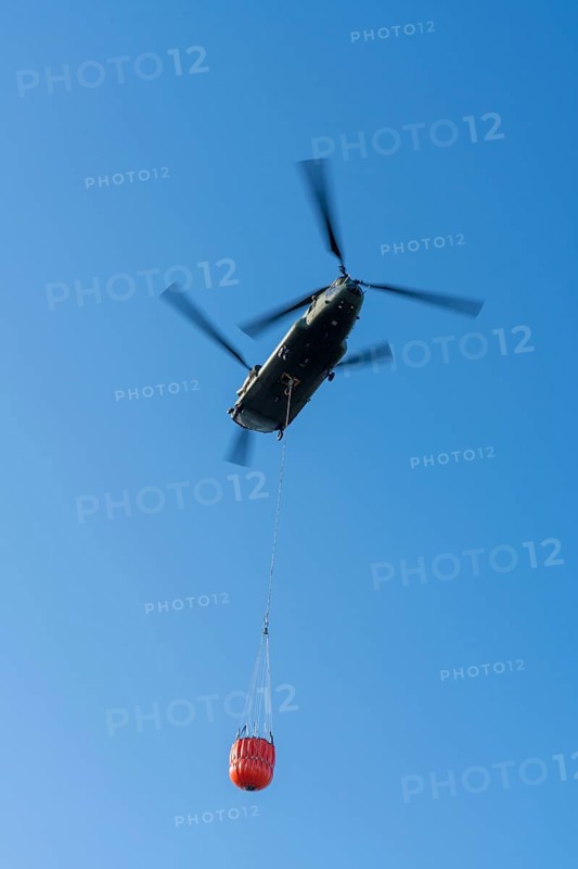 Forest fire in the German-Dutch border region near Niederkrüchten-Elmpt, in a nature reserve, use of fire-fighting helicopters, Boeing CH-47 Chinook helicopter, of the Dutch Air Force with extinguishing water tank, Bambi Bucket max