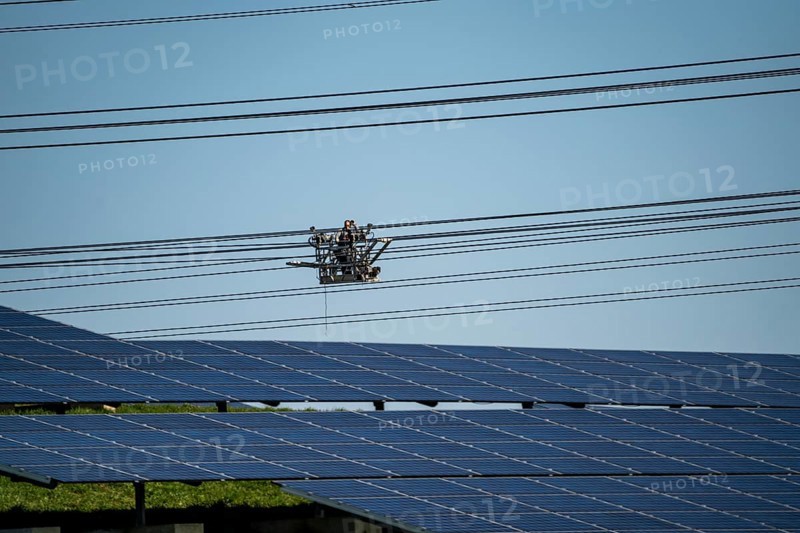 Construction of a new line route, 380 KV extra-high voltage line between Osterath and Gohr, near Neuss, fitters in line trolleys, on the conductor ropes, installing field spacers at great heights, solar park on a disused landfill site, North Rhine-Westphalia, Germany, Europe