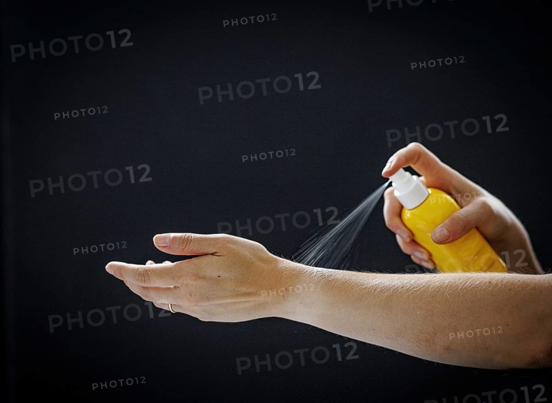 A person sprays a liquid on their arm in Berlin, 09/08/2024
