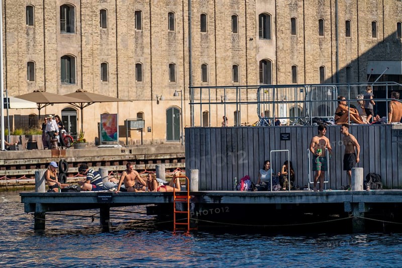 Old warehouses at Strandgade, in Christianshavns, pubs, cafés, restaurants, people hanging out at the pier, summer in Copenhagen, Denmark, Europe