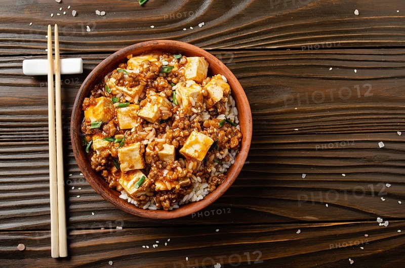 Flat lay view at mapo tofu dish with pork chives steamed rice and soy sauce closeup