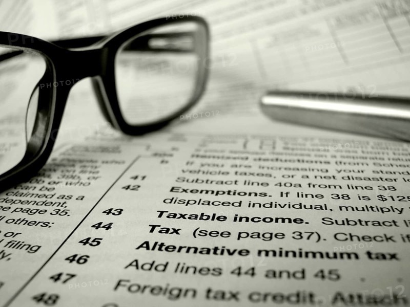 Financial Image Of Some Tax Forms With Glasses And A Pen