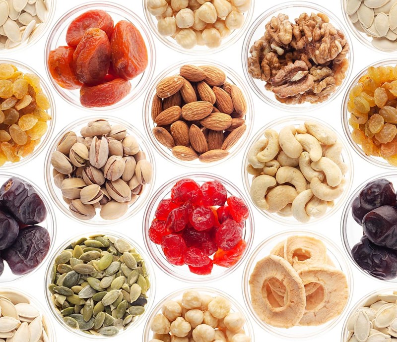Seamless food background made of nuts, dried berries and dry fruits on white