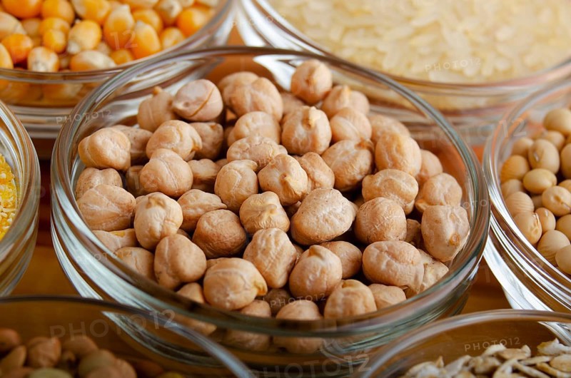 Chickpeas closeup in glass bowl on wooden kitchen table, non-perishable, long shelf life food concept