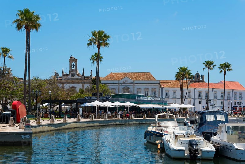 An idyllic harbour with boats and palm trees next to historic buildings in sunny weather, Doca de Faro, marina, Faro, Algarve, Portugal, Europe