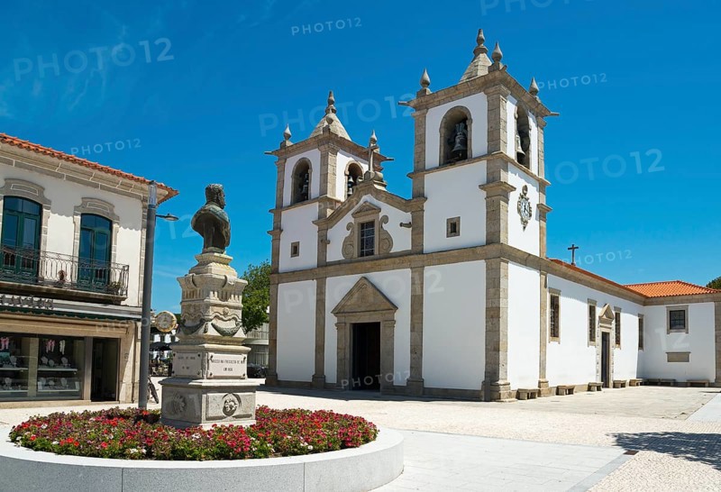 A church with a double tower stands on a sunny square with a flower bed, Igreja Matriz de Esposende, in front of it a monument by António Rodrigues Sampaio, Esposende, União das Freguesias de Esposende, Marinhas e Gandra, Norte, Portugal, Europe