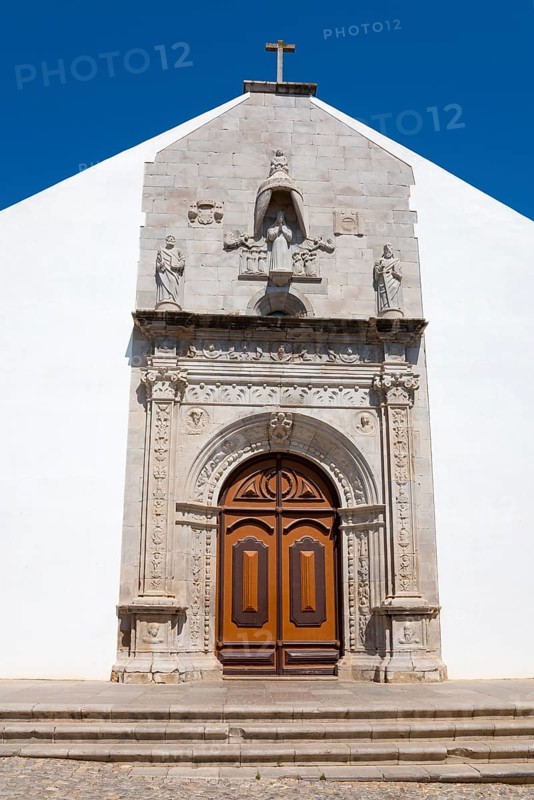 Historic church façade with detailed stonework and wooden door under a blue sky, Igreja da Misericórdia, Church of Mercy, Art Museum, Tavira, Faro, Algarve, Portugal, Europe