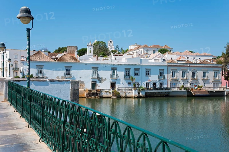 Bridge with green railing along a calm river, historical buildings in the background, Ponte Romana, Roman bridge, Roman bridge over the river Gilão, Gilao, Tavira, Faro, Algarve, Portugal, Europe