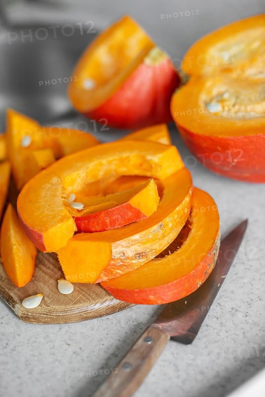 Just cut for meal preparing pumpkin slices on cutting board real photo made at authentic kitchen