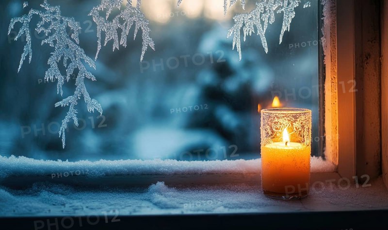 A candle is lit in a glass on a window sill. The candle is surrounded by snow, and the snowflakes are falling on the candle AI generated