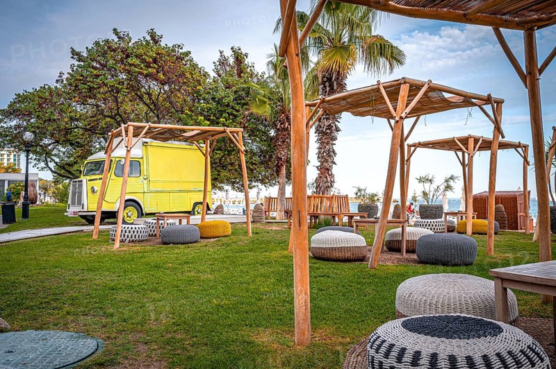 Yellow motorhome on a green meadow with rattan furniture and a view of the sea on a sunny day, Golden Sands, Varna, Bulgaria, Europe