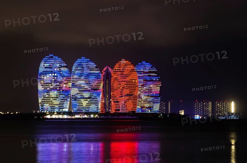 Scenic night view of buldings on Phoenix island with backlight and reflection in a sea in Sanya, Hainan, China, Asia