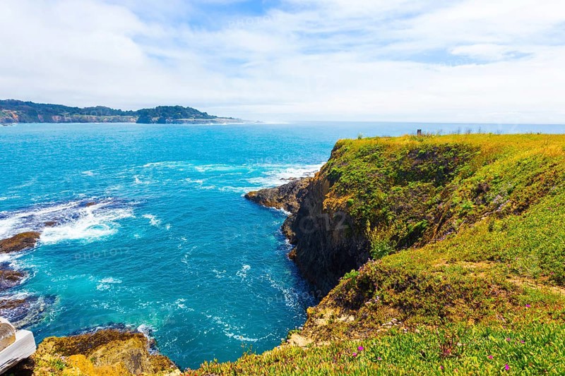 Beautiful rocky coastline and churning ocean below cliffs near Mendocino Bay on sunny day in California. Horizontal