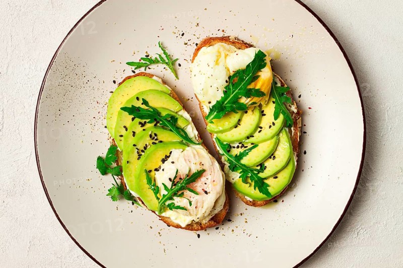 Sandwich with cream cheese, sliced avocado and boiled egg, arugula, on grainy bread, homemade, breakfast, no people