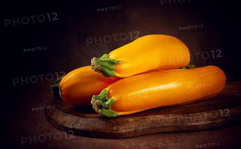 Yellow zucchini, fresh, raw, on a wooden chopping board, no people
