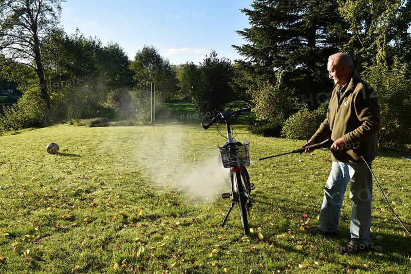 Man cleans bicycle with high-pressure cleaner