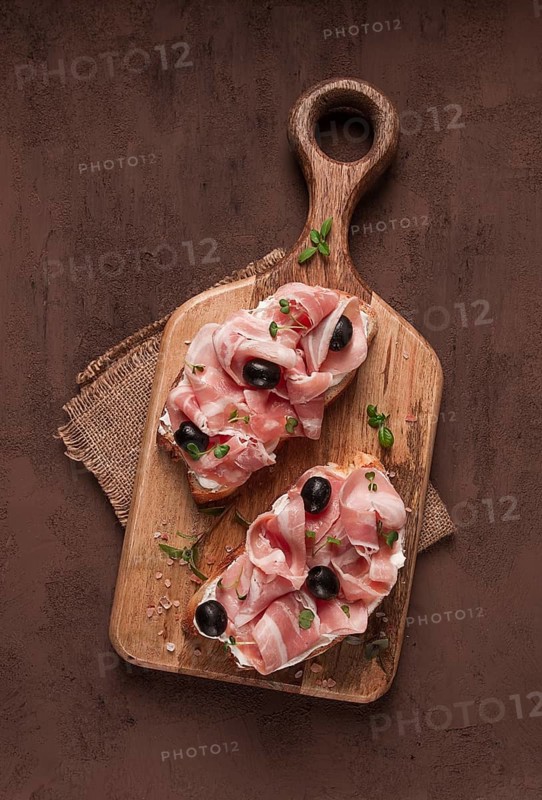 Breakfast, bacon and olives sandwich, on a cutting board, top view, close-up, no people