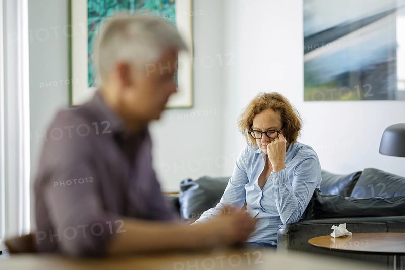 Symbolic photo on the subject of problems in a partnership. An older woman and an older man sitting at home. Berlin, 13.08.2024