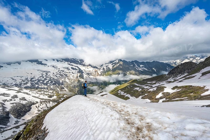 Mountaineer on hiking trail with snow, mountain landscape with summit Hoher Weißzint and Hochsteller with glacier Schlegeiskees, Berliner Höhenweg, Zillertal Alps, Tyrol, Austria, Europe