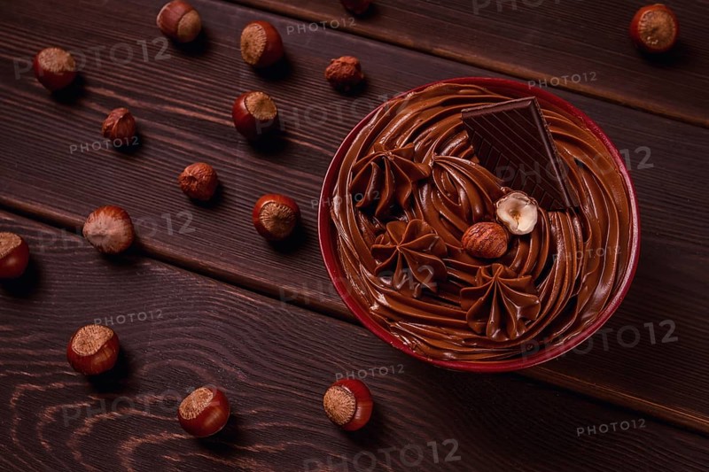 Chocolate nut paste, mousse, pasta, in a cup, on a wooden table, top view, selective focus, no people