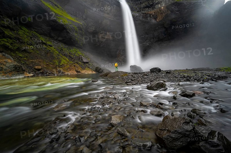 Young man with yellow jacket standing in front of waterfall, Haifoss and Granni waterfall at a canyon, Fossá í Þjórsárdal, with river í Þjórsárdal, long exposure, dramatic landscape, Hekla, Iceland, Europe