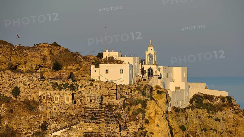 A castle and white buildings on a cliff, illuminated by the golden light of dawn with the sea in the background, morning light, Panagia Spiliani, Castle, Mandraki, Nisyros, Dodecanese, Greek Islands, Greece, Europe