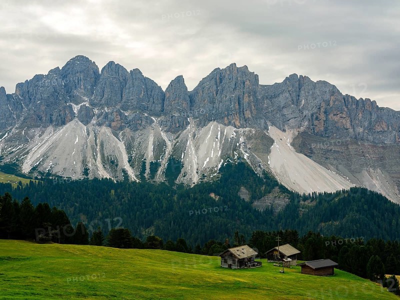 Alpine huts in front of the Geisler peaks under a cloudy sky, Villnöss Valley, Sass Rigais, Dolomites, South Tyrol, Italy, Europe