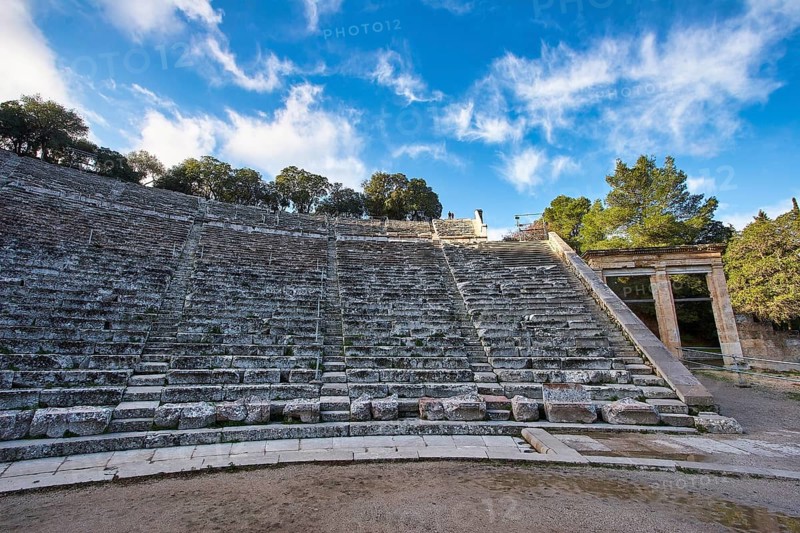 The ruins of an ancient theatre with empty stone steps and a clear blue sky, Ancient Amphitheatre, Epidaurus, Peloponnese, Greece, Europe