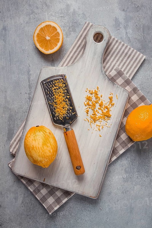 Grated lemon zest, on a cutting board, with a grater, top view, no people