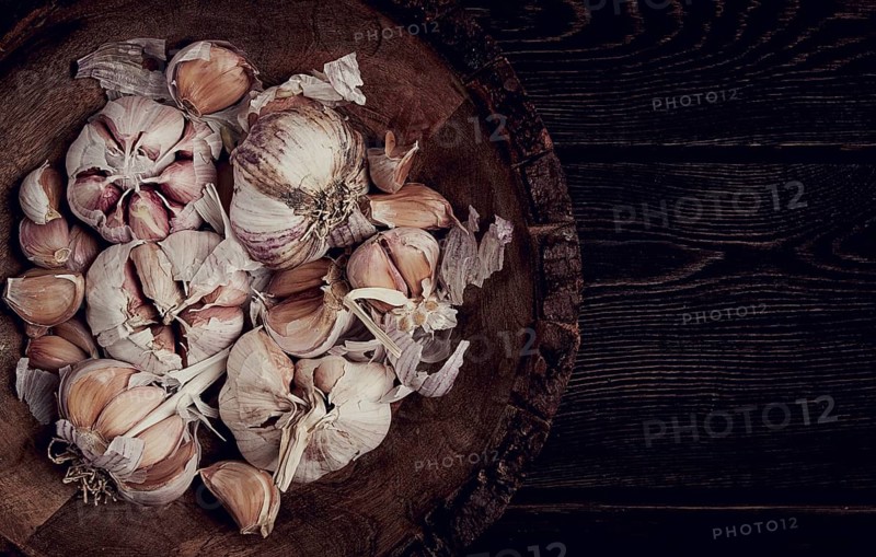 Fresh garlic, in a wooden plate, top view, close-up, no people