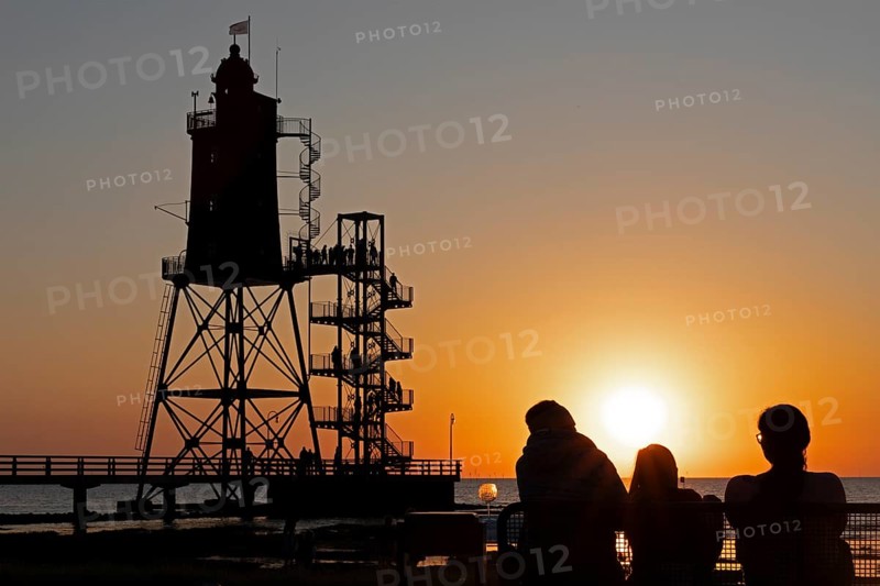 Sunset, lighthouse Obereversand, silhouettes, people, North Sea, Dorum-Neufeld, Wurster Land, Lower Saxony, Germany, Europe