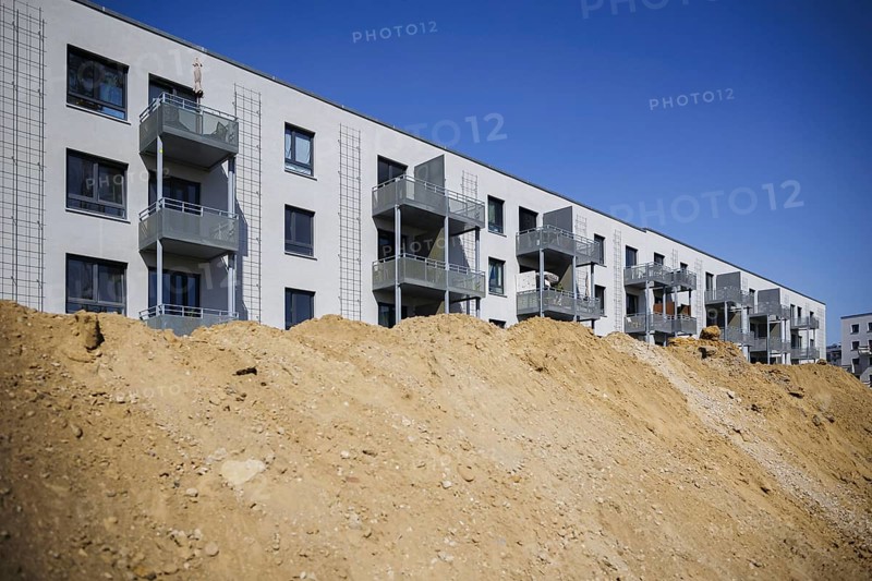 Symbolic photo on the subject of new housing construction. Buckower Felder neighbourhood on the southern outskirts of Berlin. Around 900 flats are being built on the 16-hectare site. Piles of earth pile up in front of completed rental flats. Berlin, 29.08.2024