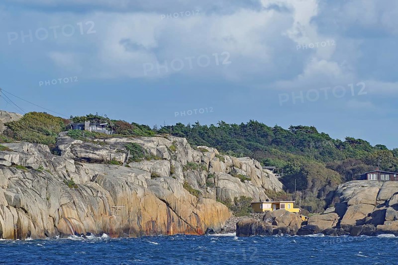 Coastal landscape with rocks, a house and wooded background under a cloudy sky, Archipelago, Sandefjord, Norway, Europe