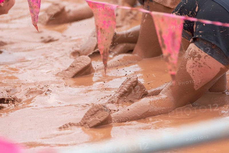 Participants dig through the mud in a competition