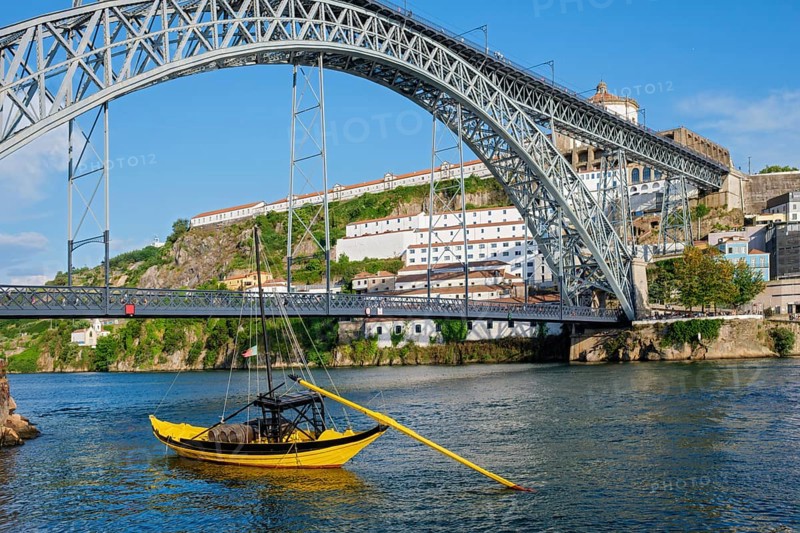 View of Vila Nova de Gaia city with Mosteiro da Serra do Pilar monastery and Dom Luis I bridge over Douro river with traditional boat with port wine barrels. Porto, Vila Nova de Gaia, Portugal, Europe