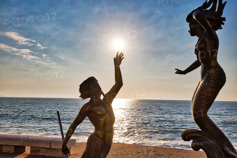 Puerto Vallarta, Mexico-20 April, 2018: Famous sculptures on scenic ocean boardwalk (El Malecon) at sunset