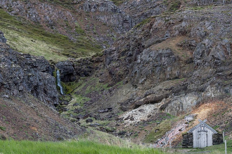 Old hut with stone walls and grass roof, waterfall, Laugar, Westfjords, Iceland, Europe