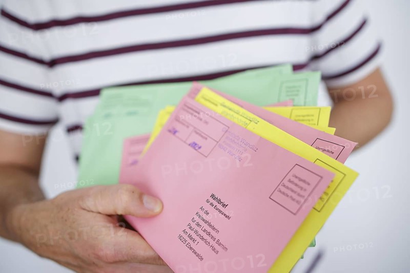A man holds postal voting documents for the European elections, district council elections and municipal council elections in Brandenburg. Berlin, 04.06.2024