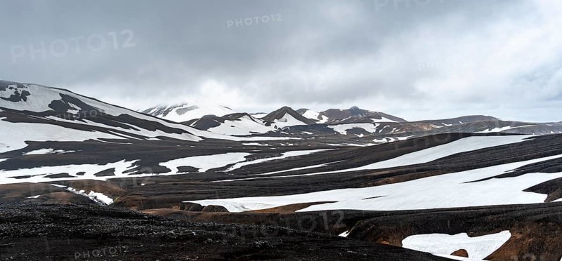 Dramatic volcanic landscape with mountains and snow, at Höskuldsskáli hut in Hrafntinnusker, Laugavegur trekking trail, Landmannalaugar, Fjallabak Nature Reserve, Suðurland, Iceland, Europe