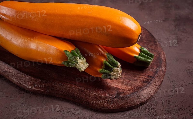 Yellow zucchini, fresh, raw, on a wooden chopping board, no people